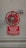 A large red control valve mounted on a neutral-colored wall, with a metal chain attached to it. Below the valve, a red sign reads 'Dual Feed System' and provides instructions for isolating the sprinkler system.