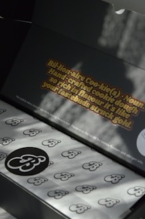 Elegant biscuit boxes open to reveal neatly arranged personalized sablés with minimalist designs.