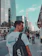 A smiling young man carrying a sleek Xantop backpack on a busy city street.