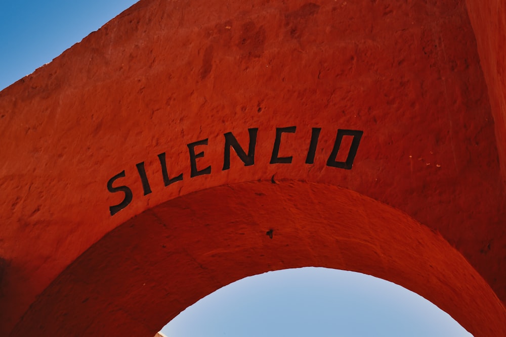 a close up of a red arch with a sky in the background