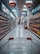 A supermarket aisle with products lined up on both sides. The view is from behind a shopping cart, looking down the aisle towards a distant checkout area. Overhead signs indicate sections for oil and pickles/jam. Shelves are neatly stocked with various bottled and packaged goods.