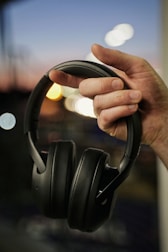 a person holding a pair of headphones in their hand