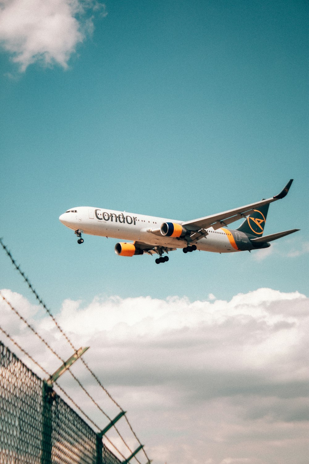 a large jetliner flying through a blue cloudy sky