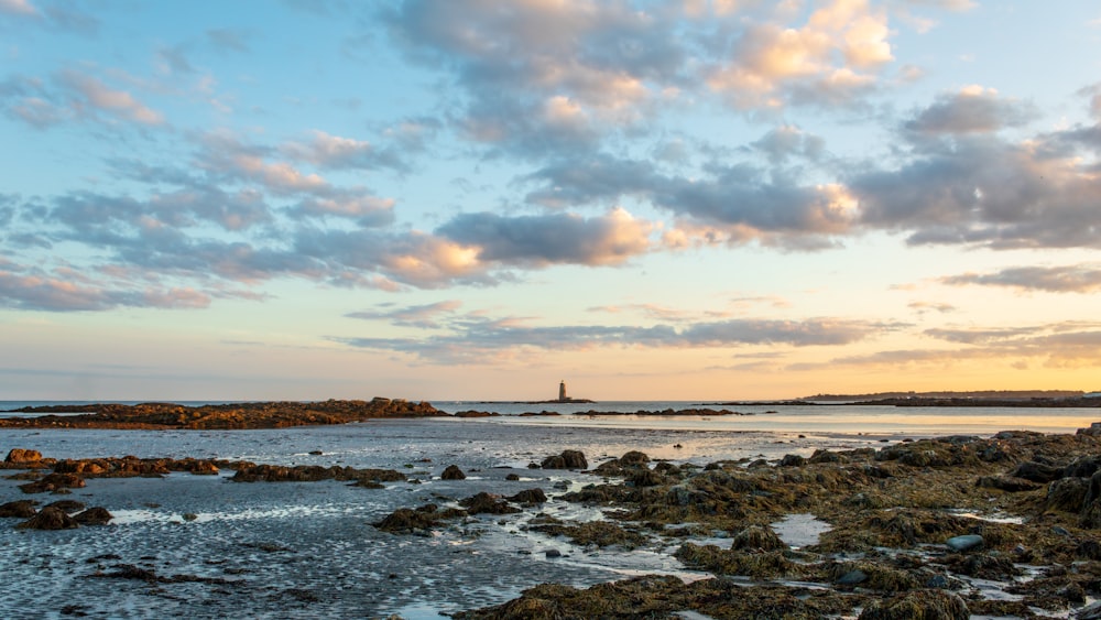 a beach with a lighthouse in the distance