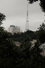 A close-up of a hand signing a contract with communication towers in the background