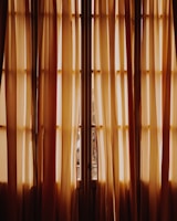 Bright bedroom featuring flowing drapes in warm, inviting colors.