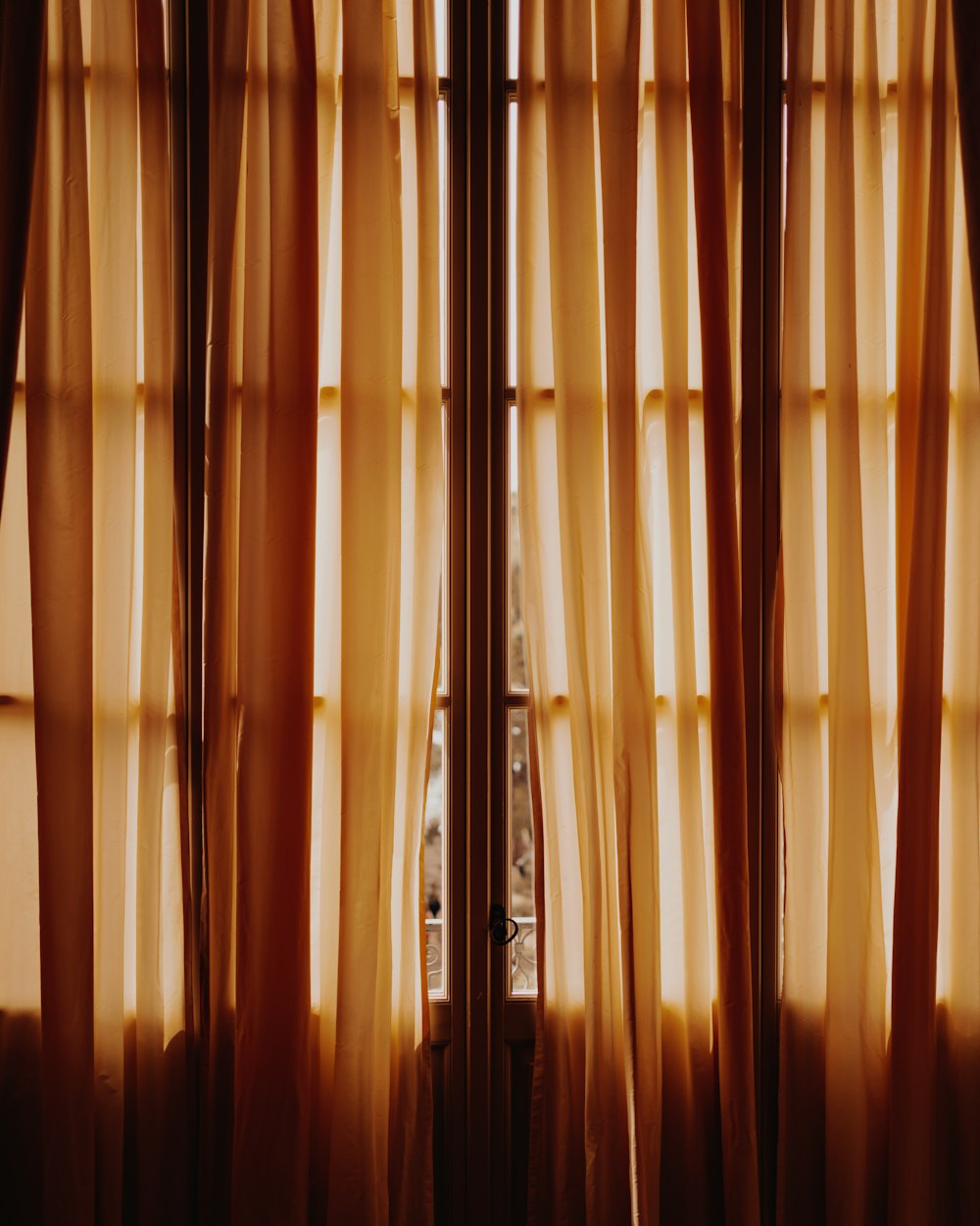 uma janela que tem algumas cortinas