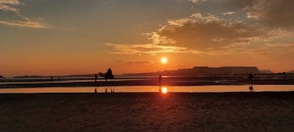 A serene sunset over the Sahara dunes with a lone camel caravan silhouetted against the golden sky.