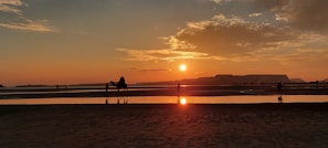 Sunset view over the Agafay desert with riders on camels.