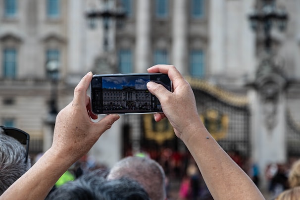 Close-up of a tourist at a cultural heritage site interacting with the light block system on their phone, capturing enhanced digital images.