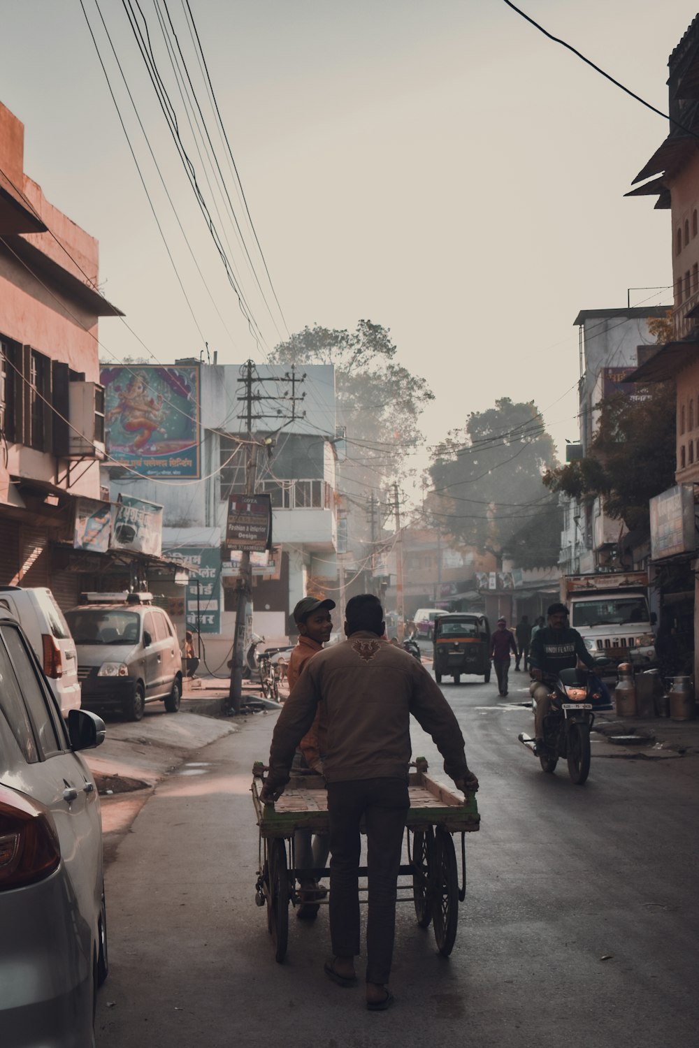 a man pushing a cart down a street