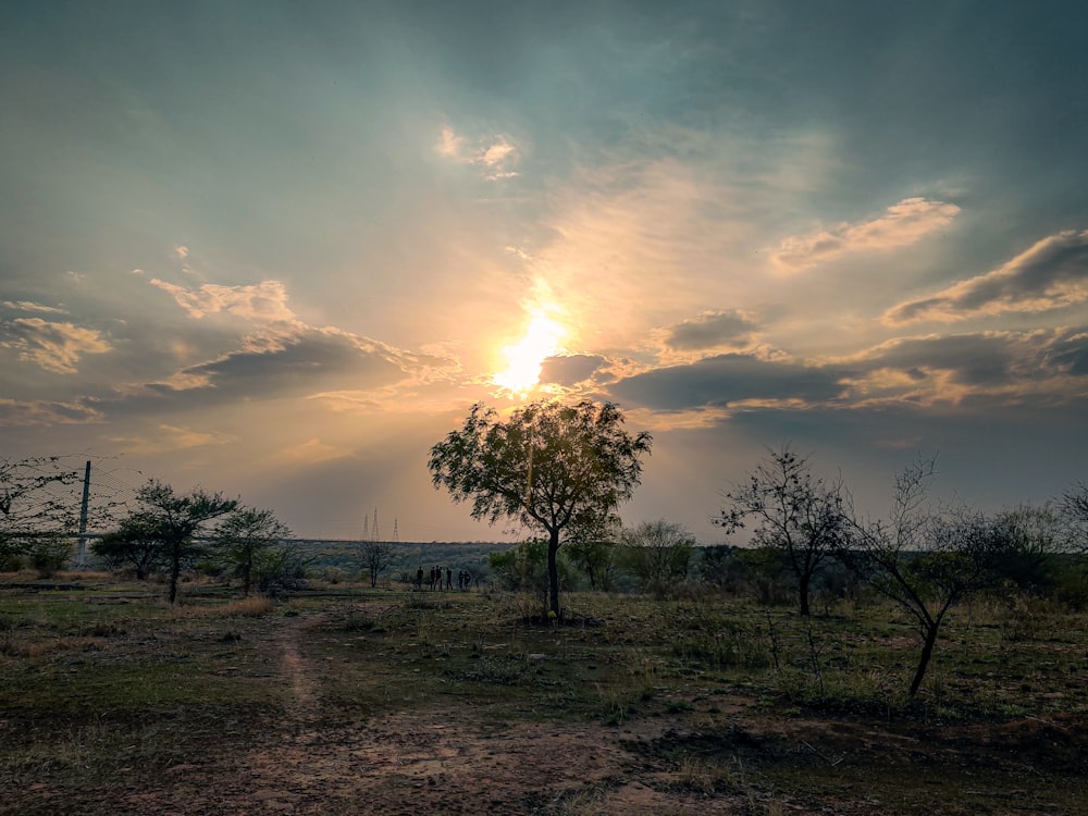 the sun is shining through the clouds over a field