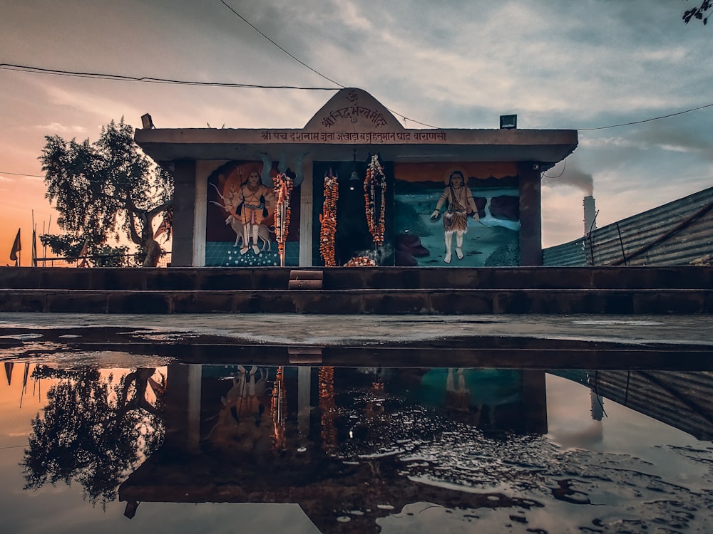 a small building with a reflection in the water