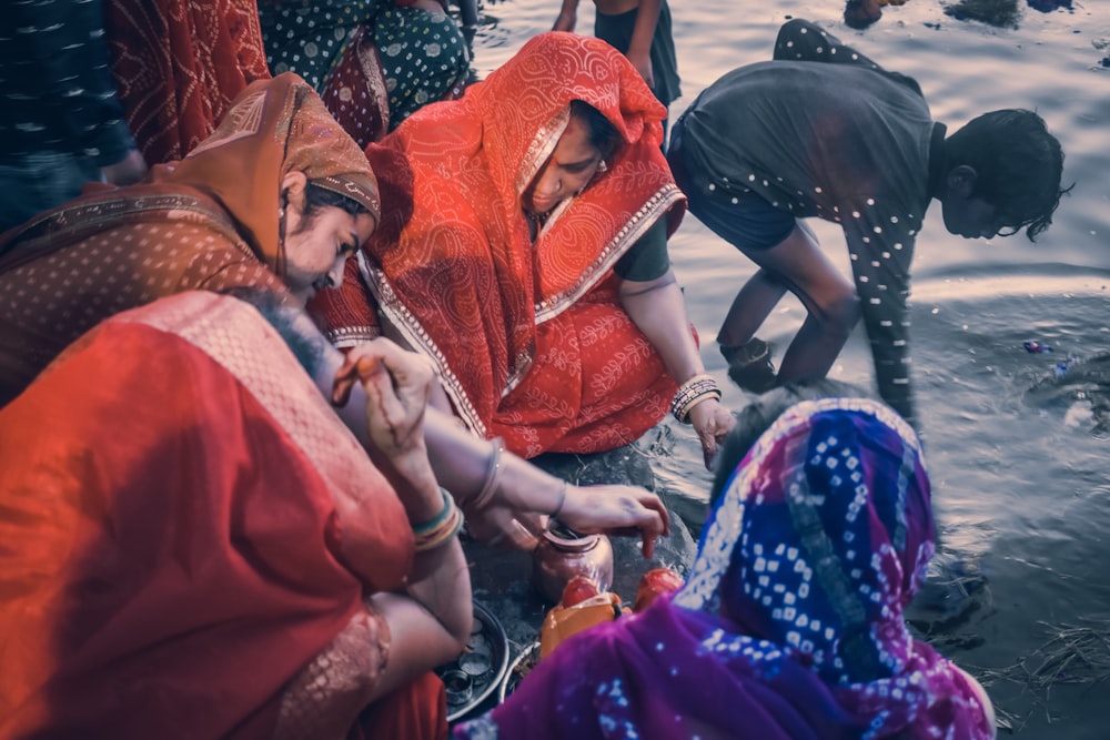 a group of people standing around a body of water