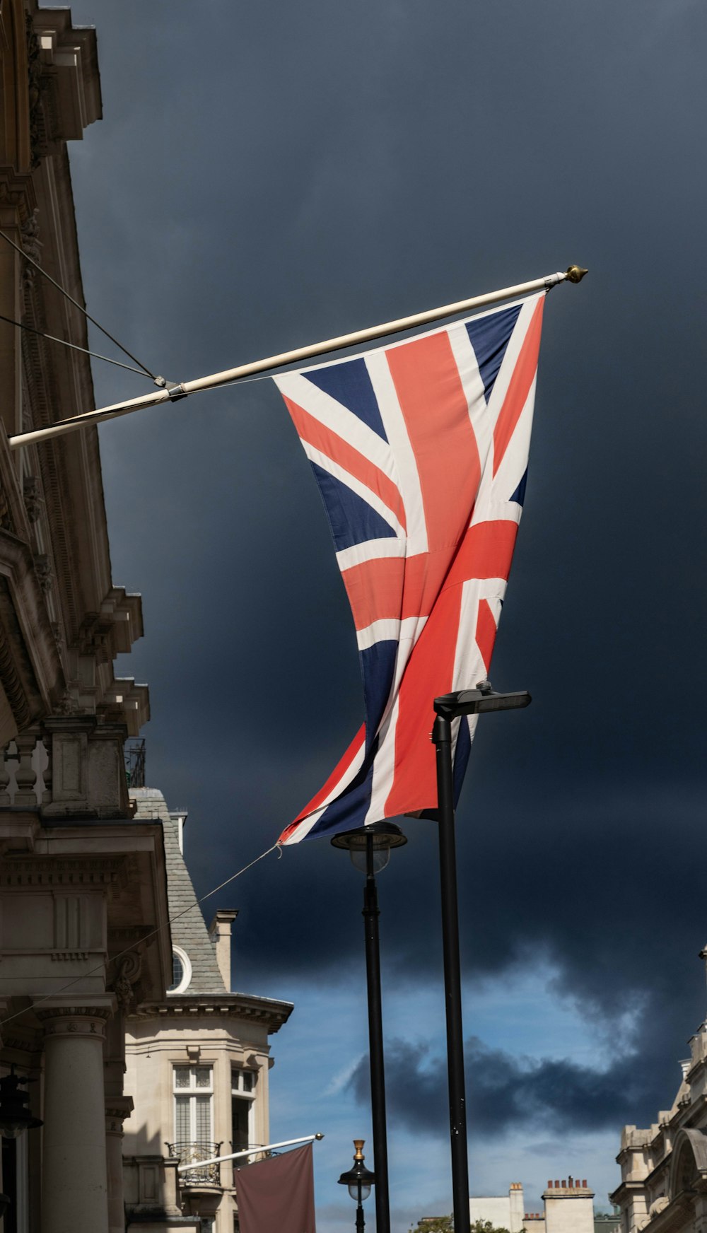 a british flag hanging from a pole in front of a building