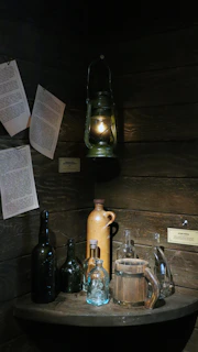An inviting medieval tavern corner with a quill and inkpot resting on a rustic wooden table beside flickering candlelight.