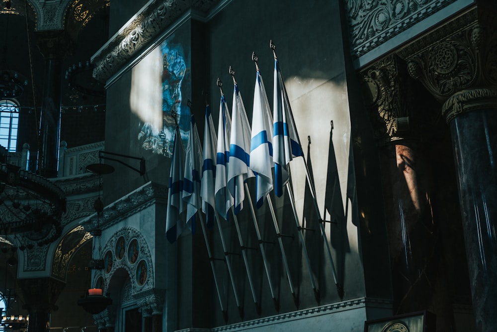 a group of flags hanging from the side of a building