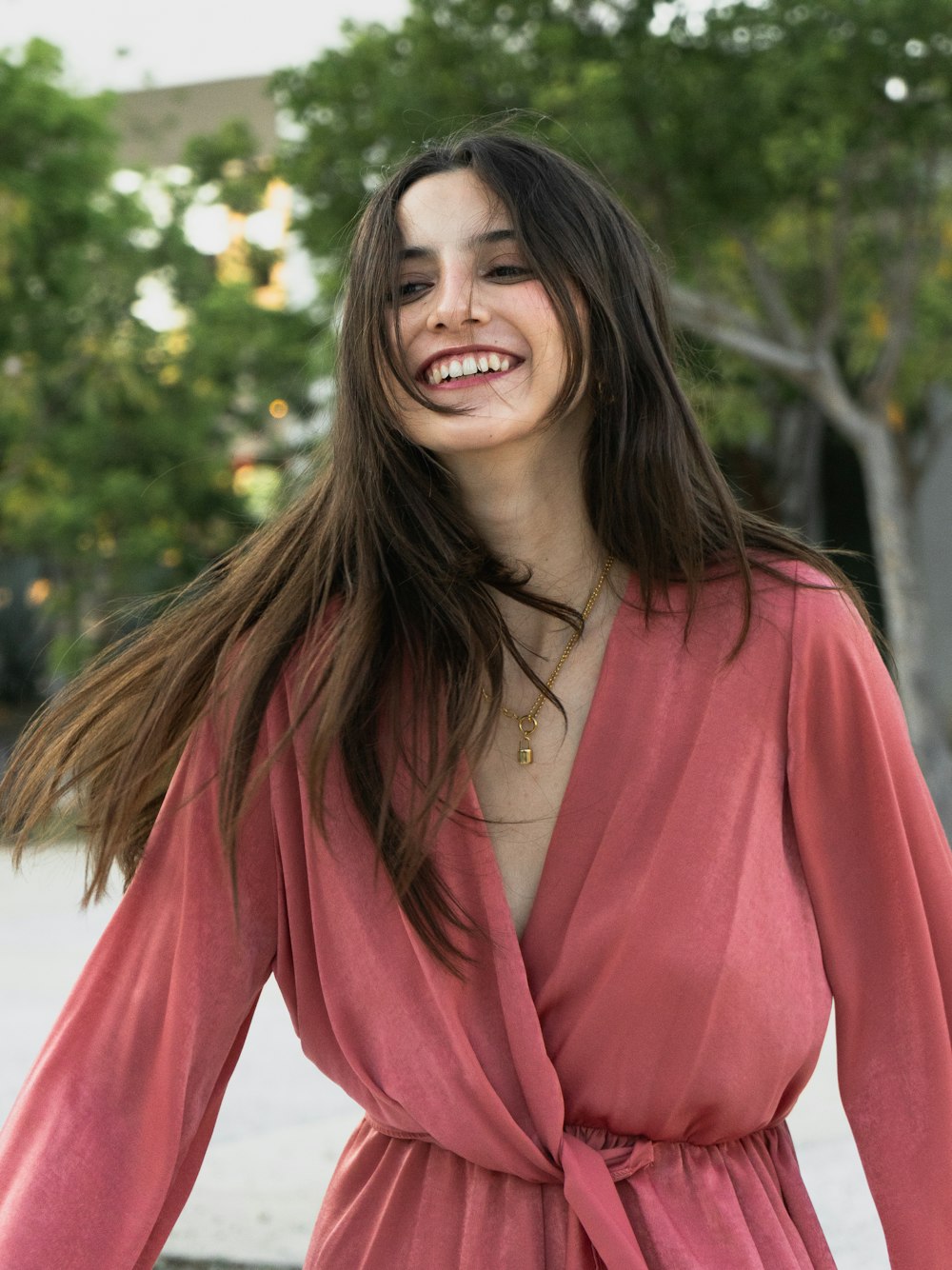 a woman with long hair wearing a pink dress