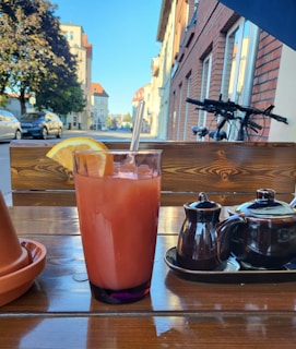 Refreshing iced tea and tropical fruit slices set beside a bustling street food stall