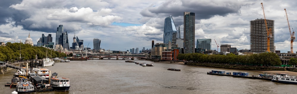 a river filled with lots of boats next to tall buildings