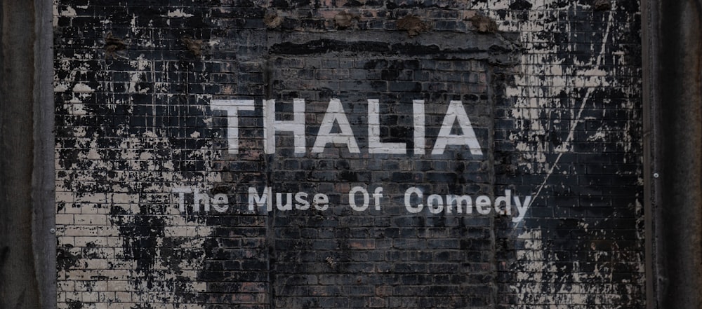 a sign on the side of a building that says thalia the museum of comedy