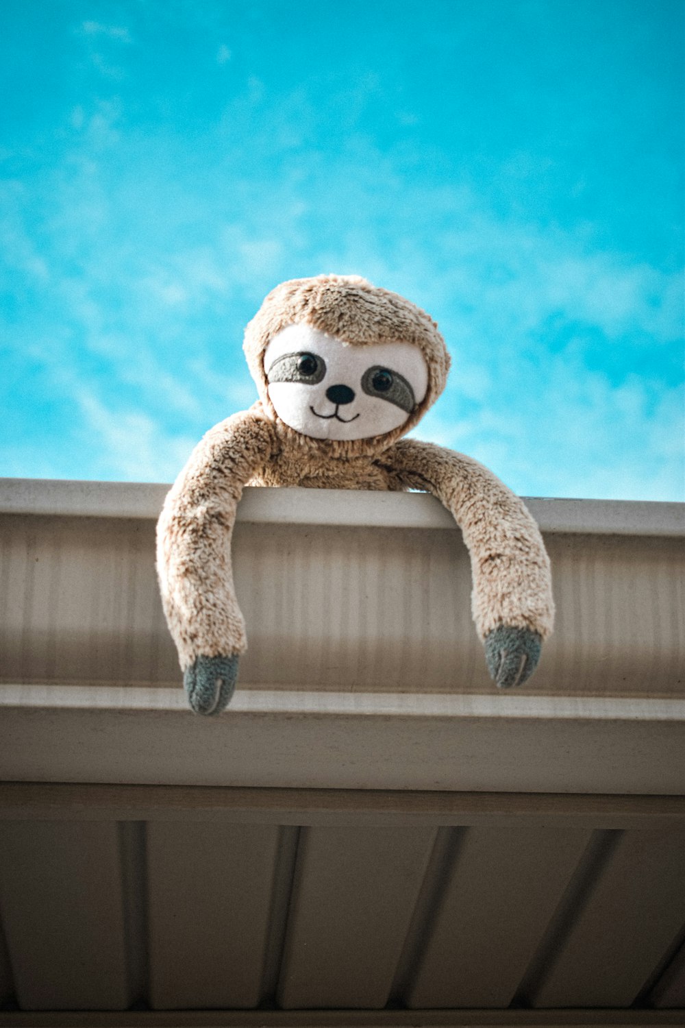 a stuffed slotty bear sitting on top of a roof
