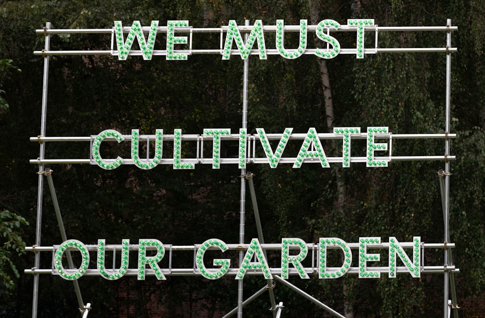 we must cultivate our garden sign on the side of a building