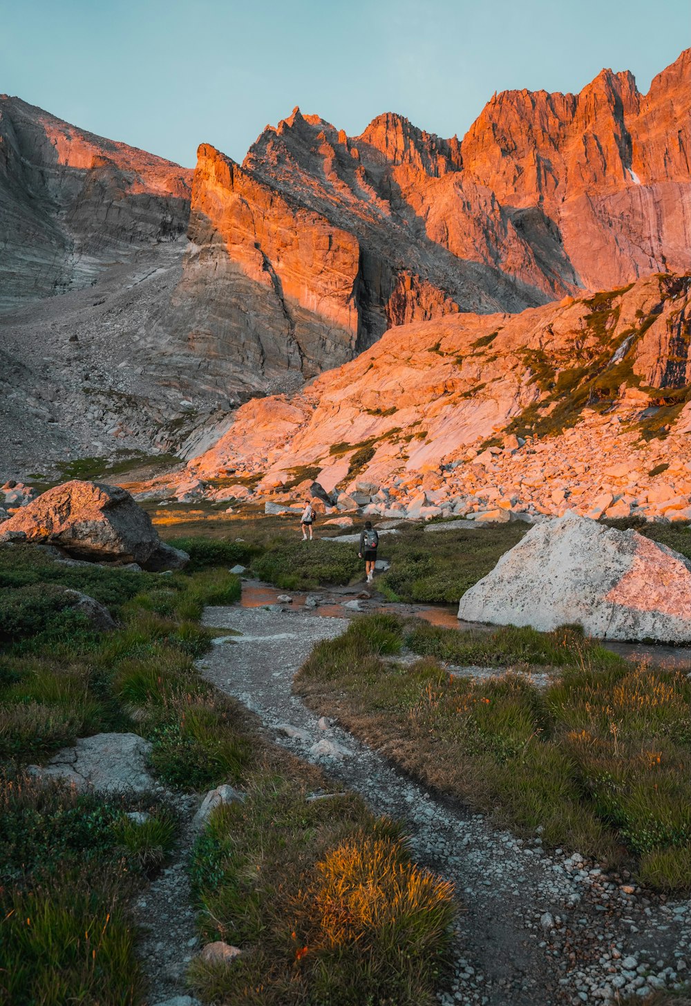 a person hiking up a trail in the mountains