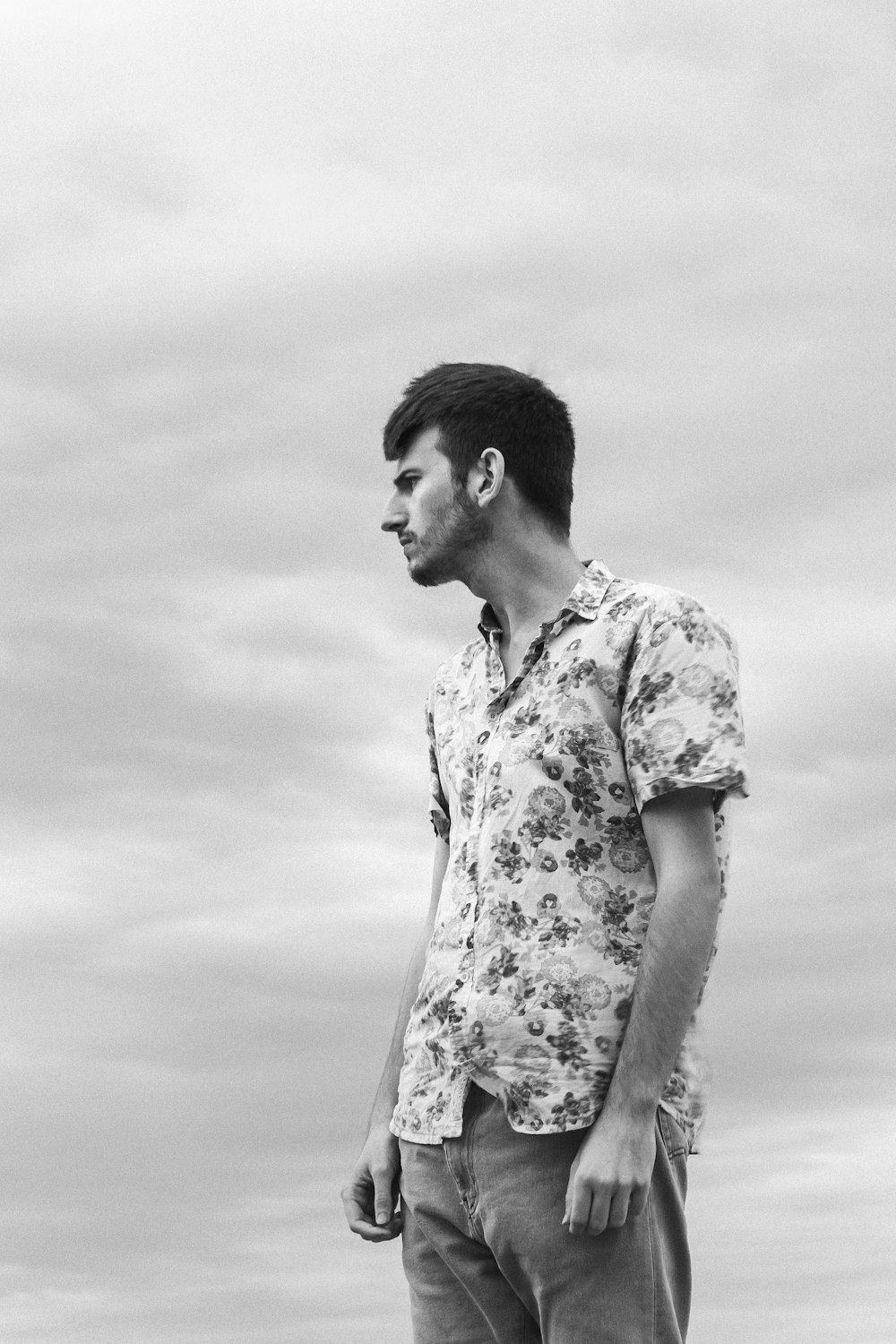 a man standing on top of a beach next to the ocean