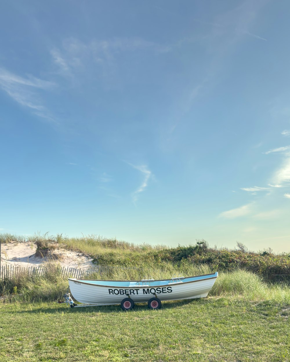 a small boat sitting on top of a lush green field