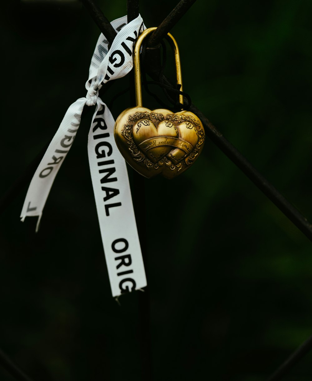 a heart shaped lock with a ribbon attached to it