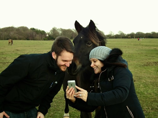 A smiling goat farmer using a smartphone to access Helix AI’s veterinary advice in a sunny rural village.