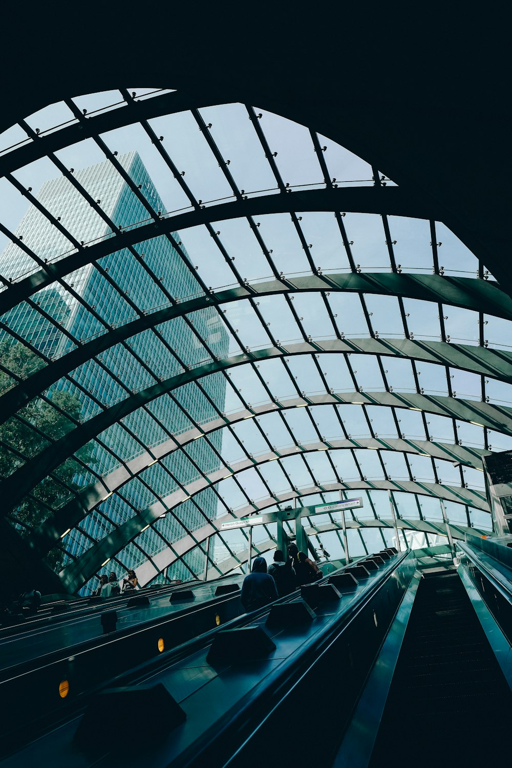 an escalator in a train station with a view of a skyscraper