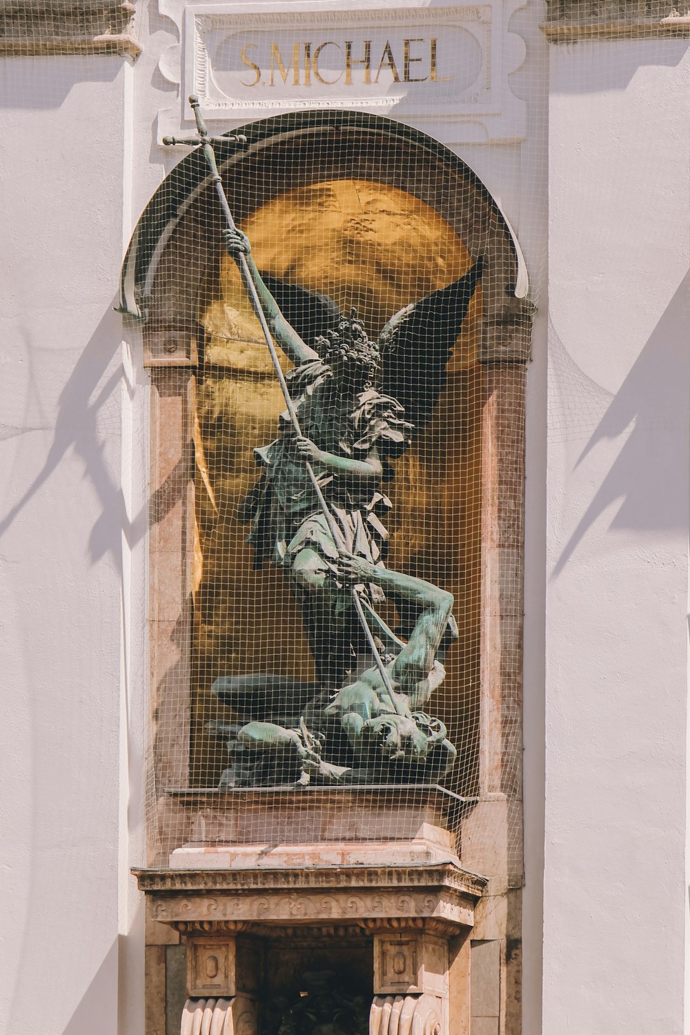 une statue d’un homme tenant une épée devant un bâtiment