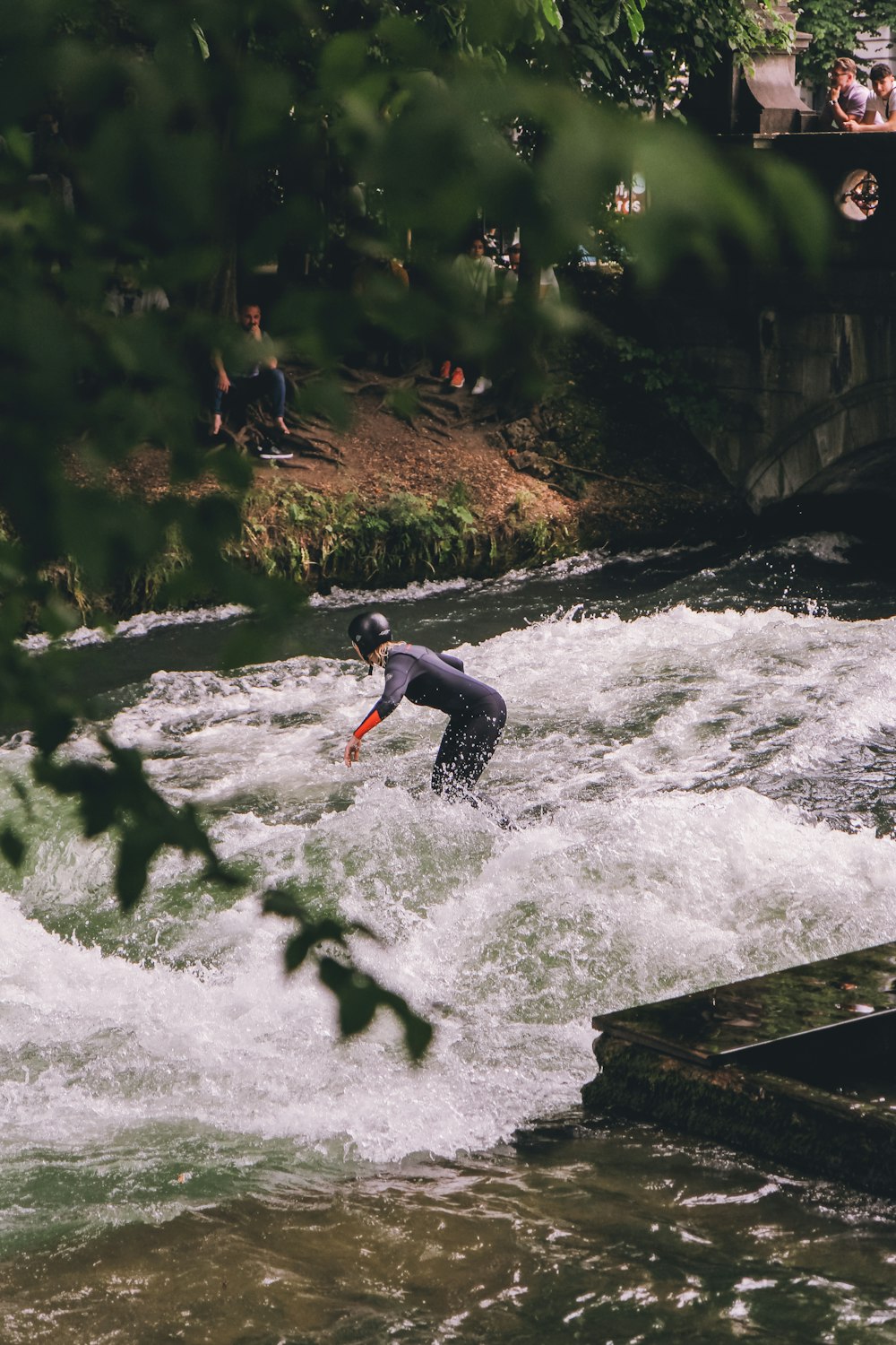 a man riding a surfboard on top of a river