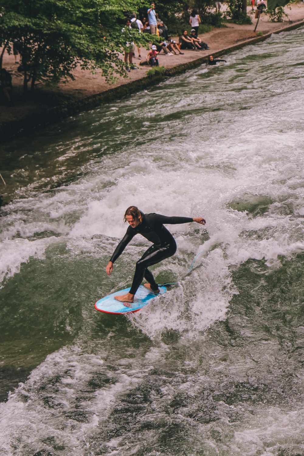 a man riding a surfboard on top of a river
