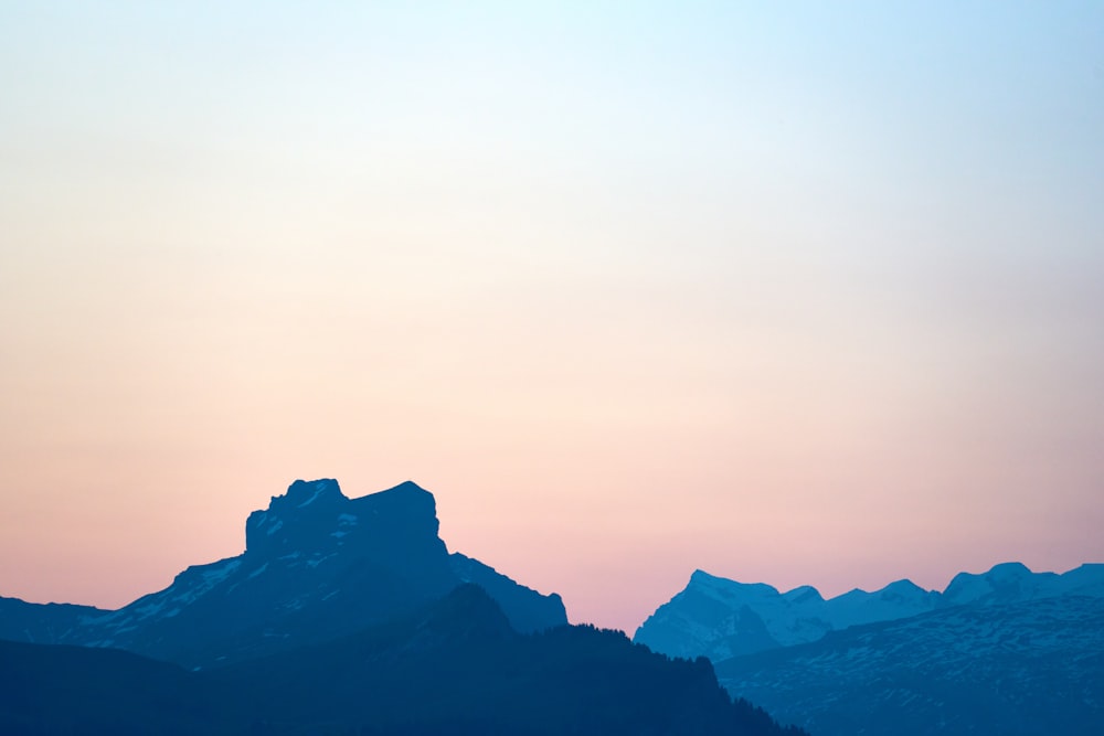 a plane flying over a mountain range at sunset