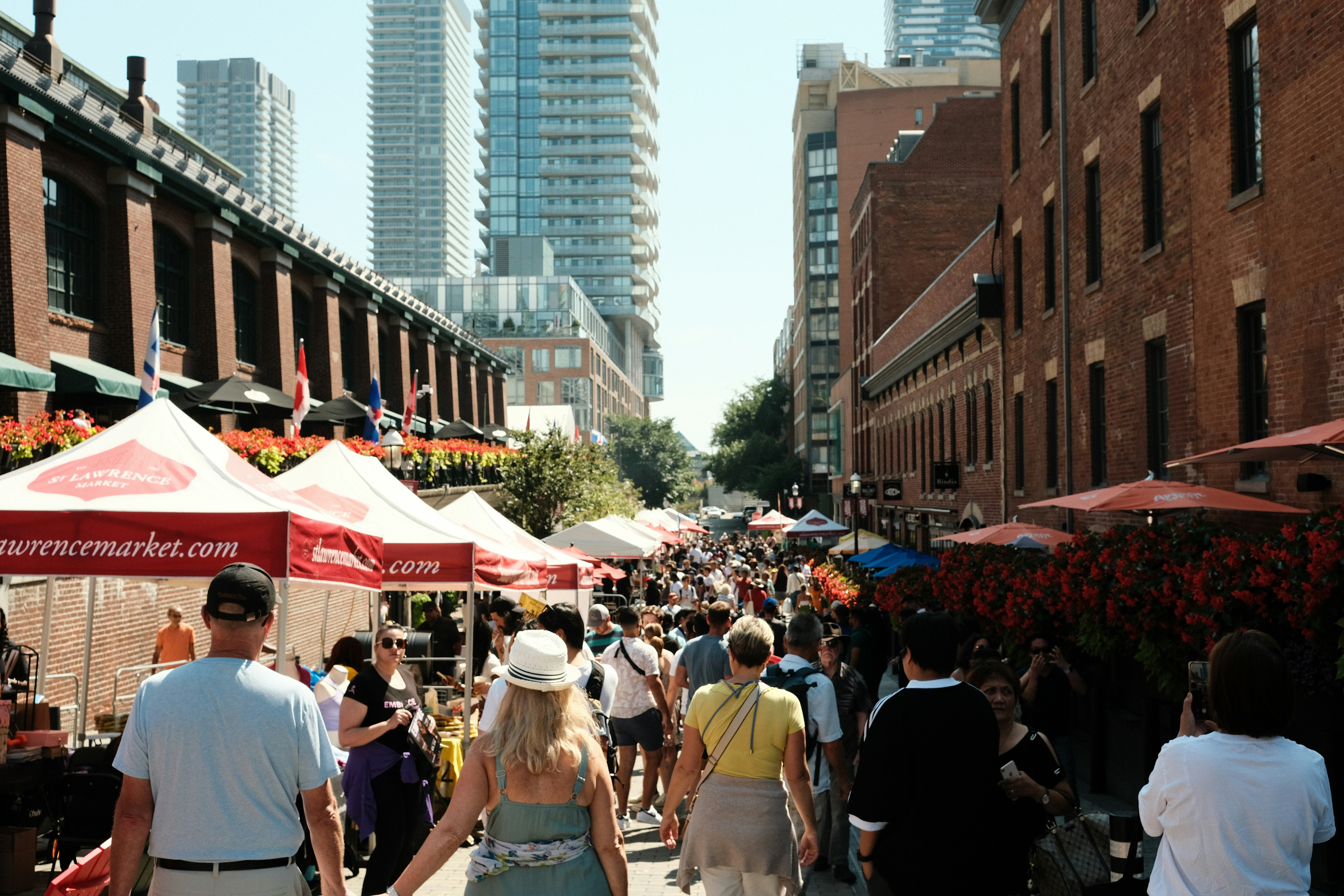 a crowd of people walking down a street next to tall buildings