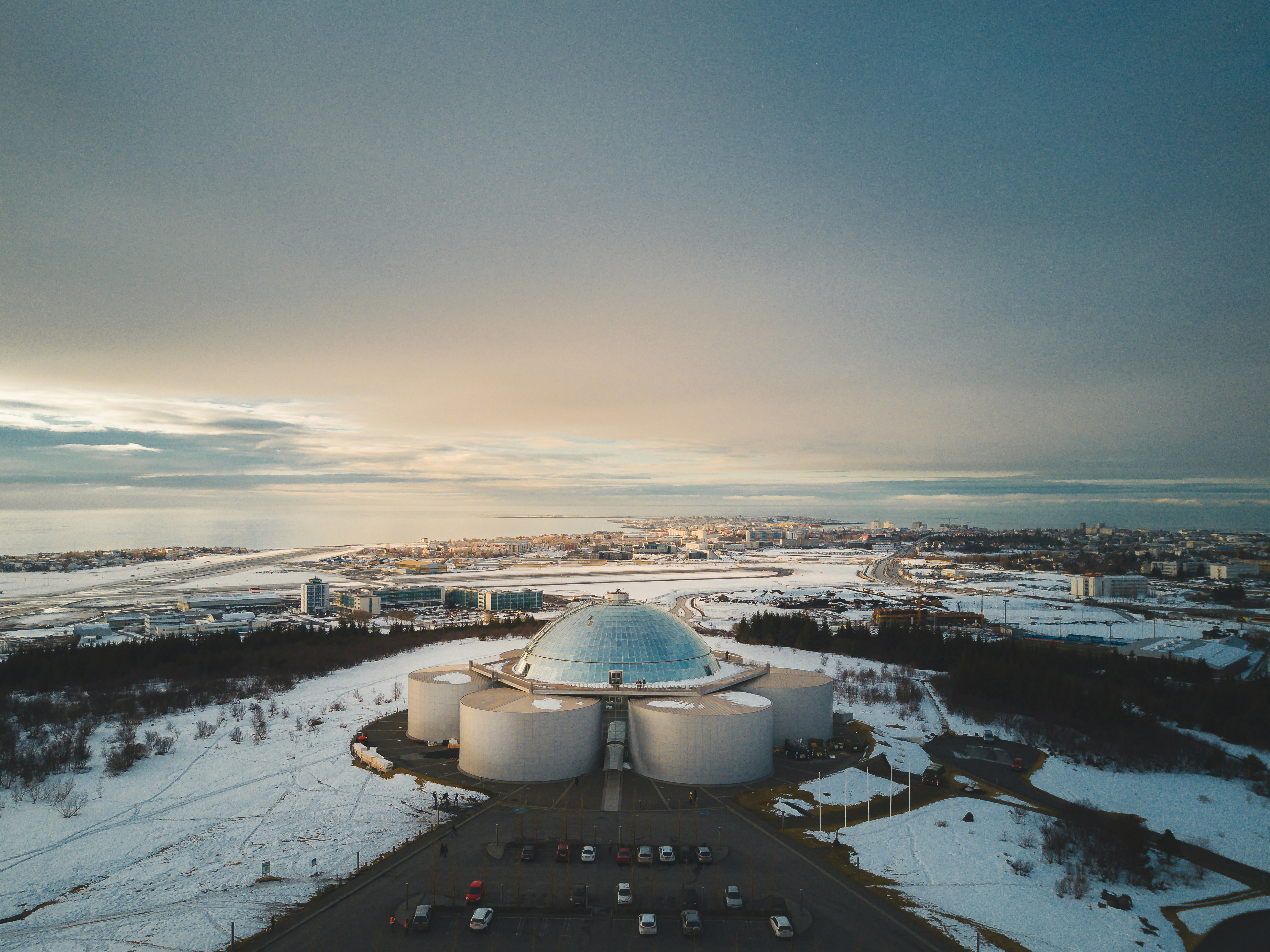 an aerial view of a large building in the middle of a snowy field