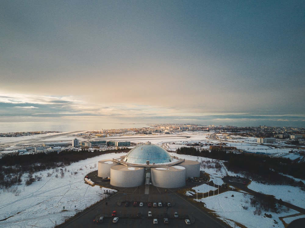 an aerial view of a large building in the middle of a snowy field