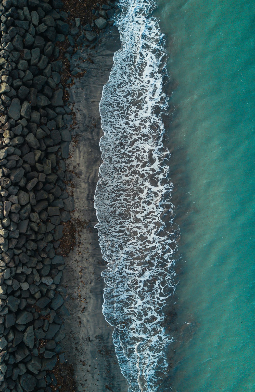 Vista aérea de uma praia com pedras e água