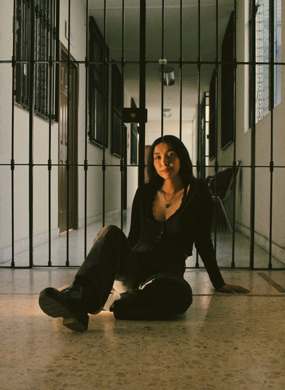 a woman sitting on the floor in a jail cell