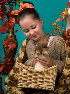 A smiling child hugging a rescued rabbit in a sunny garden.