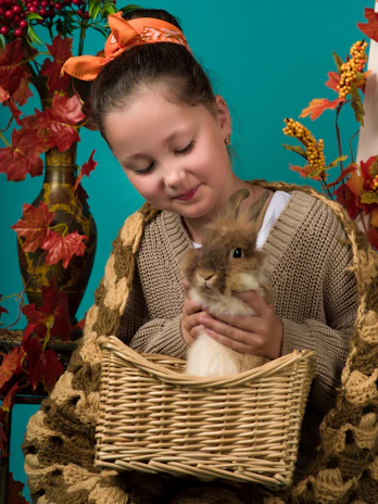 A smiling child hugging a rescued rabbit in a sunny garden.