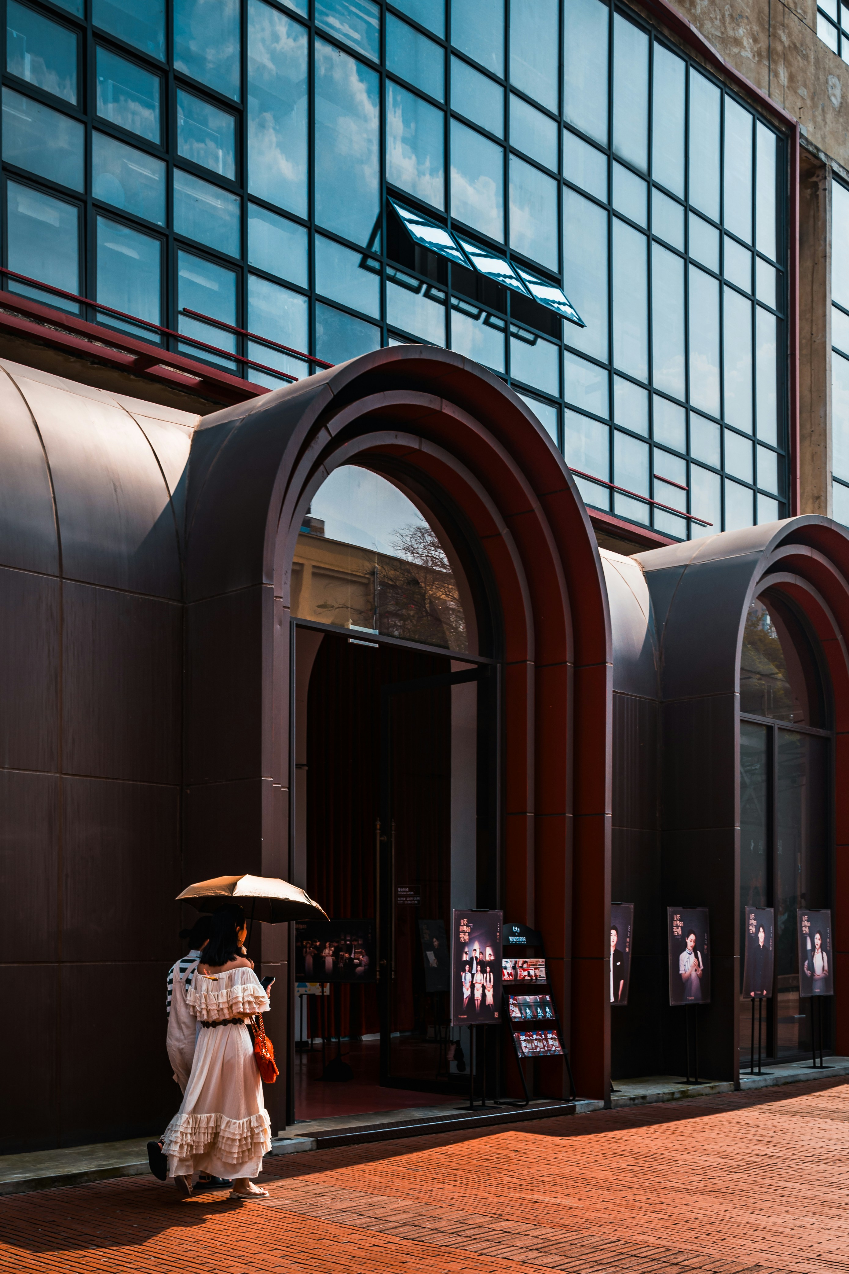 a woman walking down a street holding an umbrella