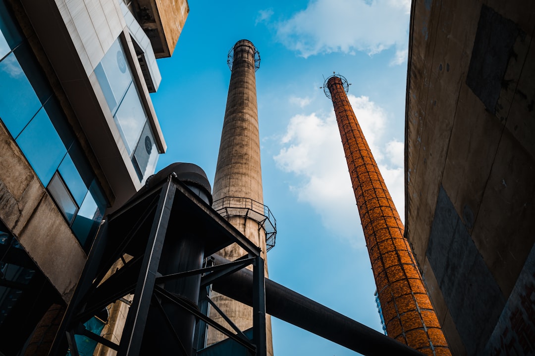 two tall industrial towers towering over a city,