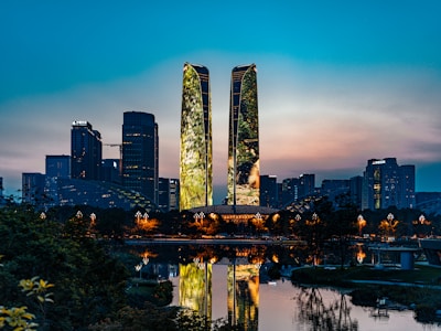 A modern city skyline featuring eco-friendly infrastructure illuminated at dusk.