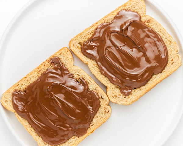 Two pieces of bread with chocolate spread on them