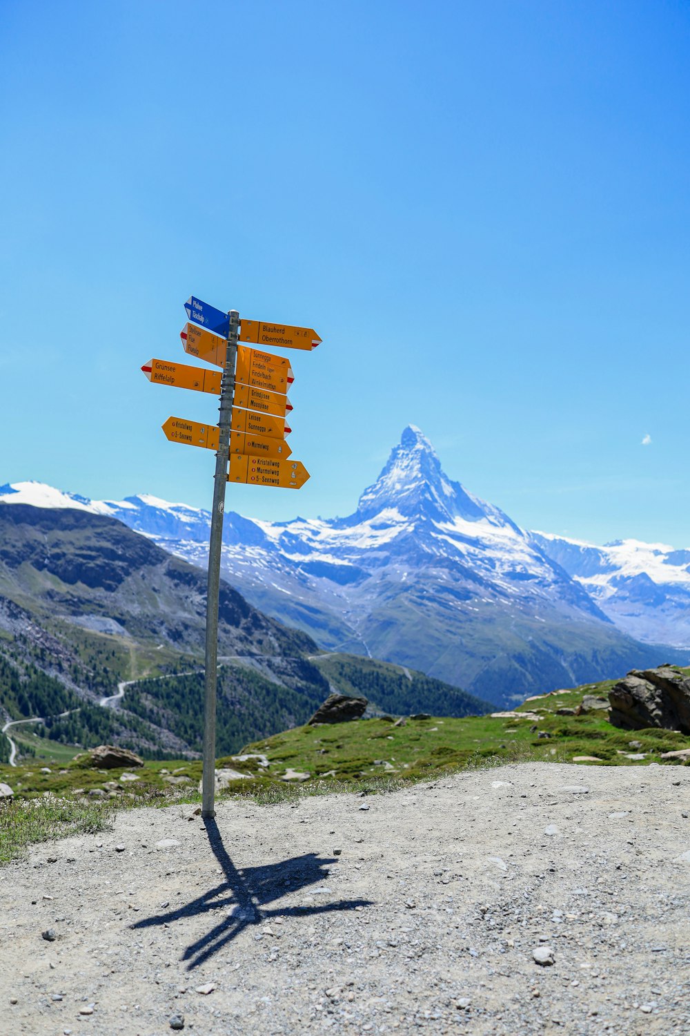 a sign post with a mountain in the background