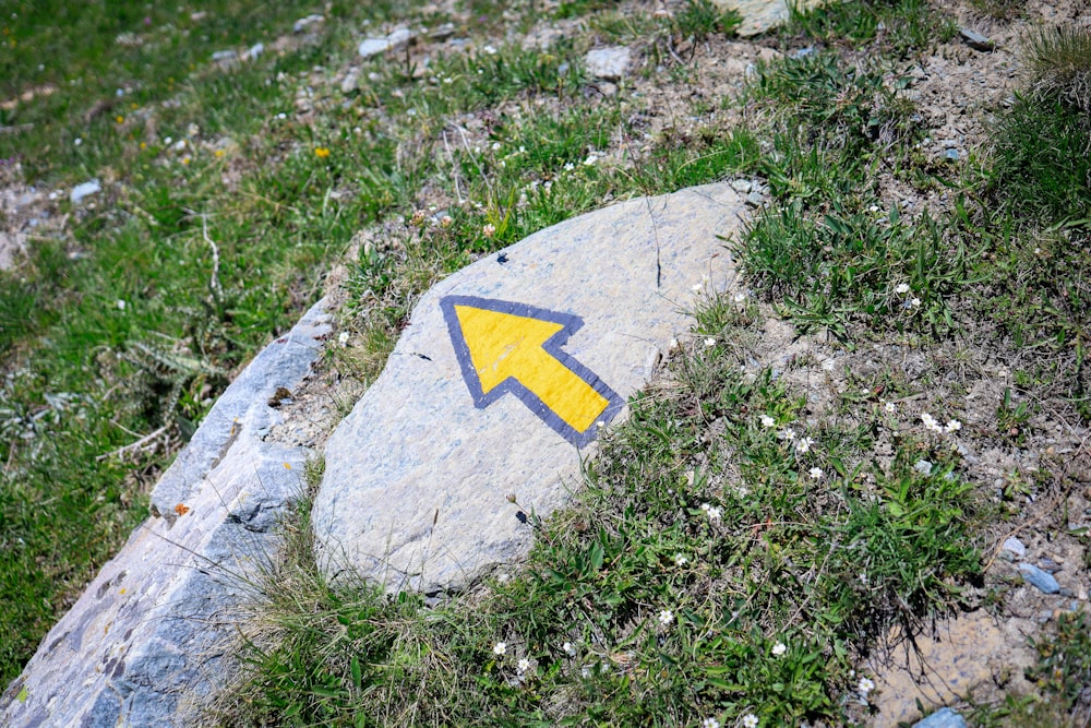 a rock with a yellow arrow painted on it